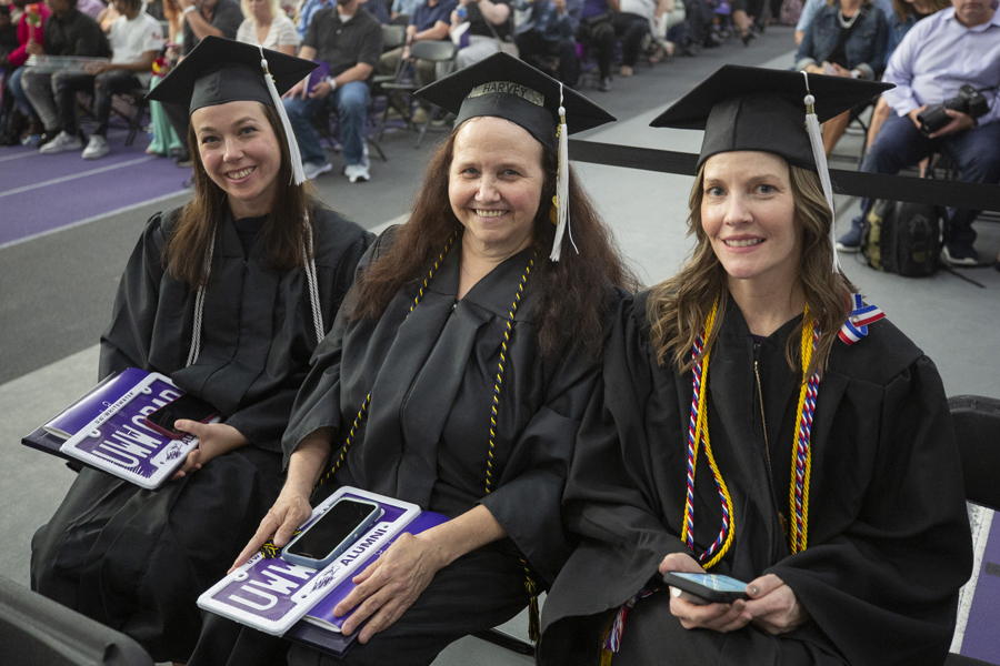 Three graduates at commencement.